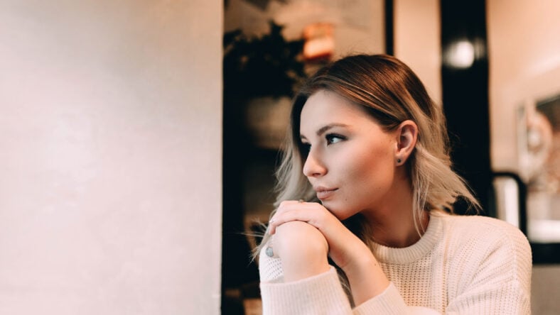 Cute blonde girl sits in a cafe