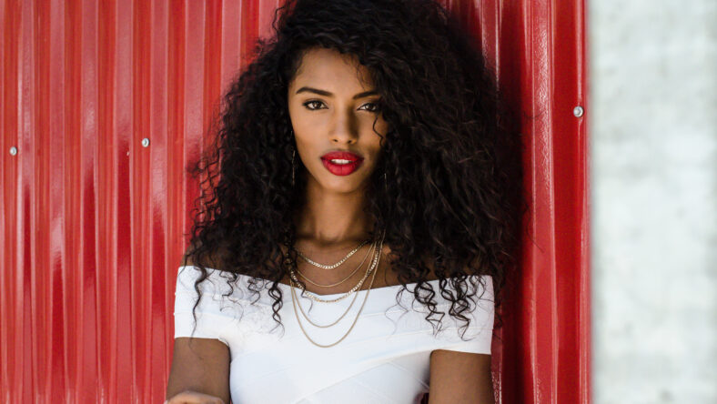 Fashionable black woman with red lips leaning