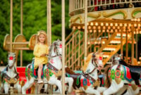 Adorable little girl near the carousel outdoors