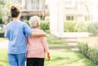 Back view of nurse caregiver support walking