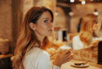 Young woman in cafe, girl drinks her