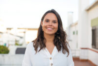 Happy Latin woman posing on apartment balcony