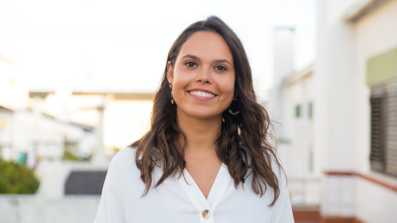Happy Latin woman posing on apartment balcony