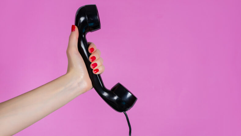 Female hand holding old and retro telephone