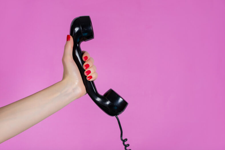 Female hand holding old and retro telephone
