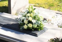 White funeral flowers on a grey marble