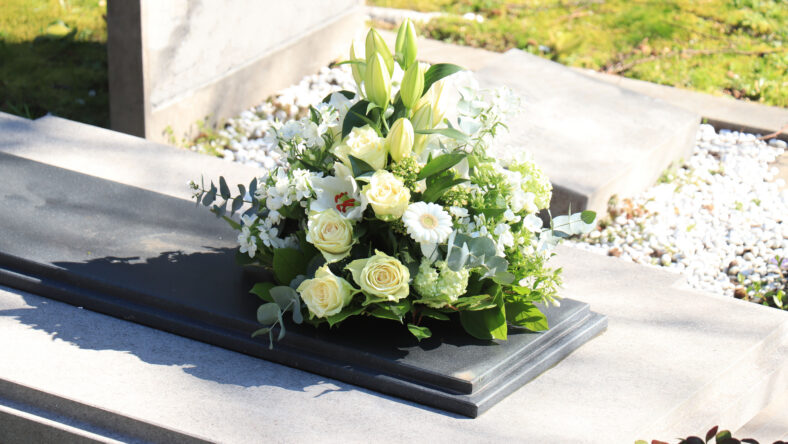 White funeral flowers on a grey marble