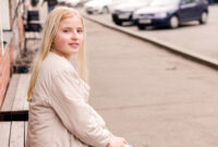 Beautiful blonde girl sitting on a bench