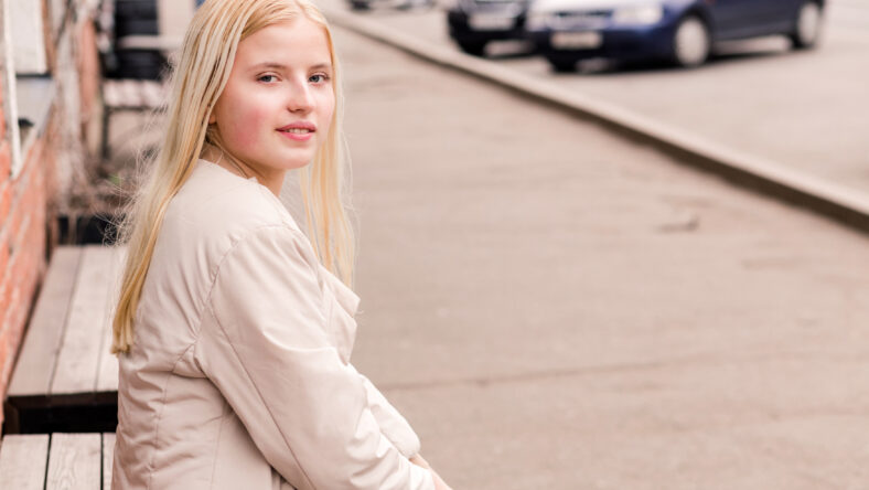Beautiful blonde girl sitting on a bench