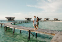 Back view couple walking together on wooden