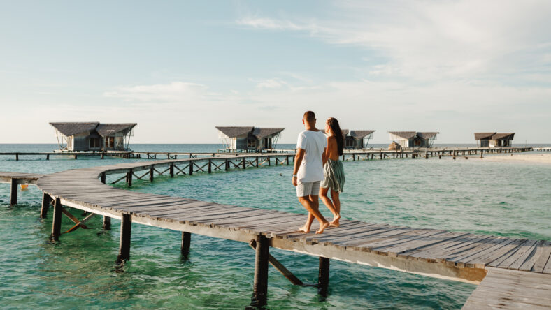 Back view couple walking together on wooden