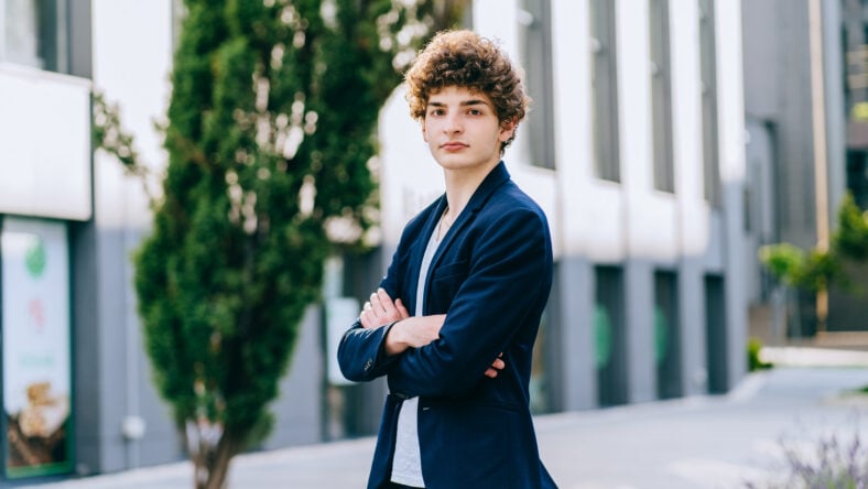 Cheerful good-looking brunet curly teenager student man