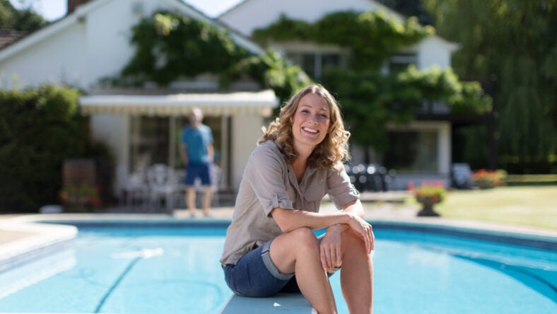 Portrait confident woman relaxing at sunny poolside