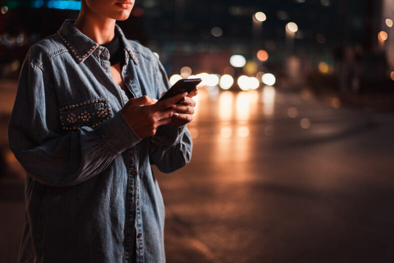 Pretty girl with stylish clothes holding smartphone