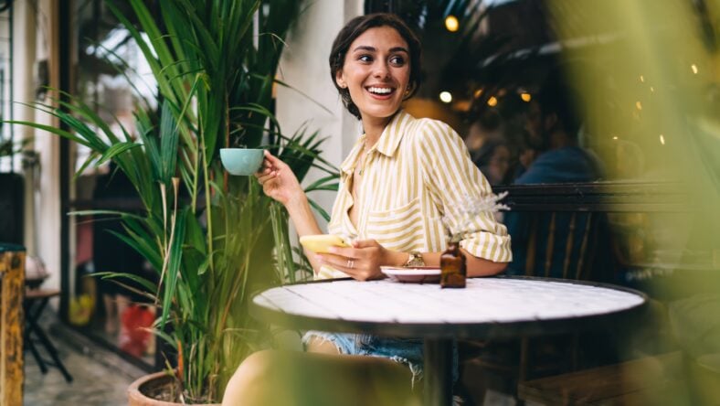 Smiling young female in casual wear drinking