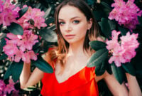 Young beautiful girl posing among the flowering