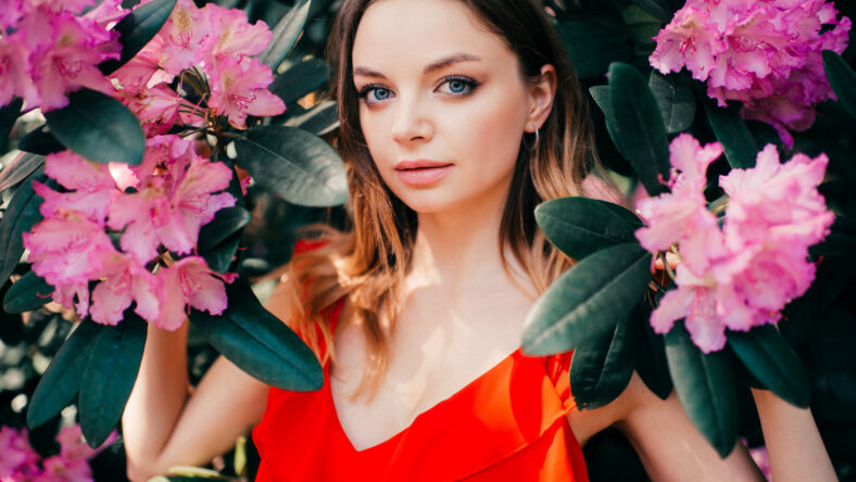 Young beautiful girl posing among the flowering