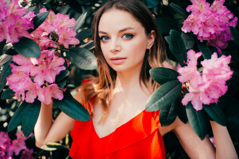 Young beautiful girl posing among the flowering