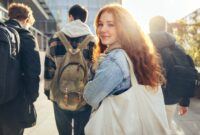 Female student glancing back while going for