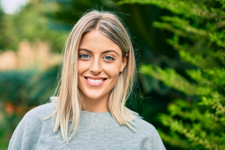 Young blonde girl smiling happy standing at