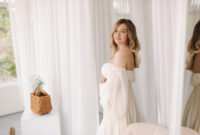 Happy pregnant woman in white dress smile