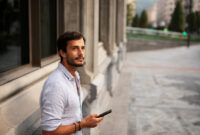 Young stylish man using the phone outdoors.
