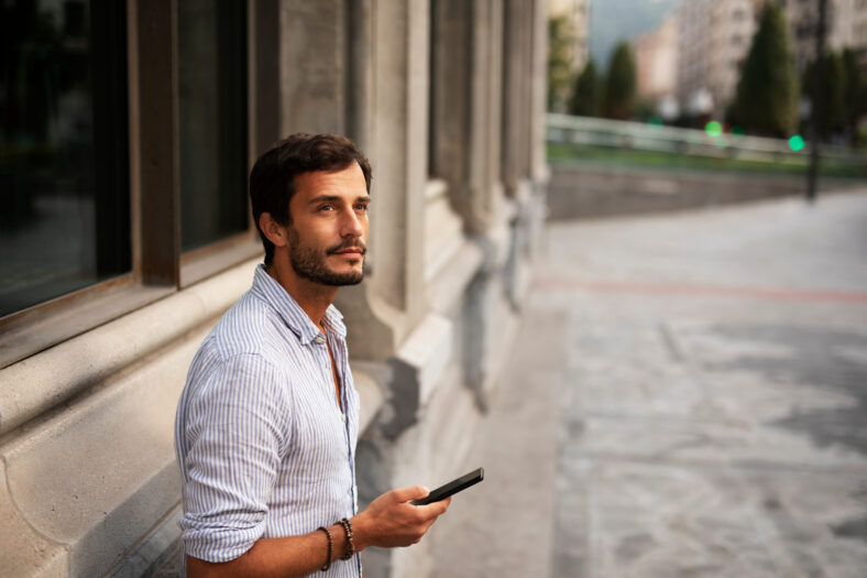 Young stylish man using the phone outdoors.