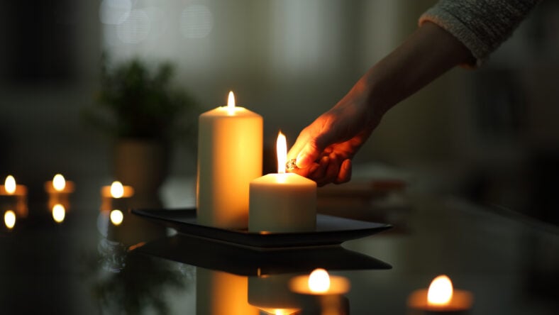 Close up of woman hand lighting candles