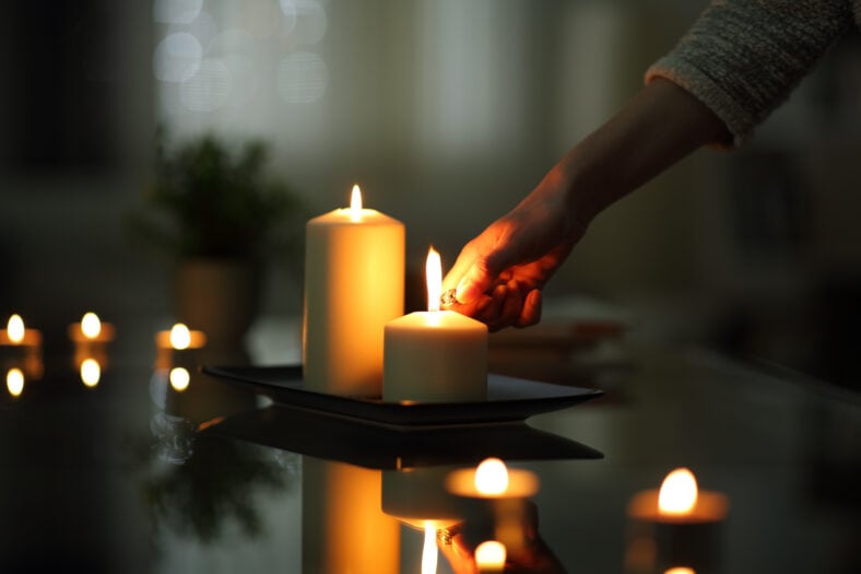 Close up of woman hand lighting candles
