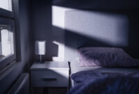 Bed at night in dark bedroom. Blue