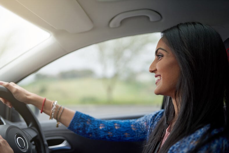 Shot of an attractive young woman driving