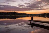 Lonely girl silhouette at sunset by the