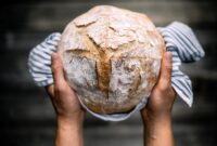 Traditional leavened sourdough bread in baker hands