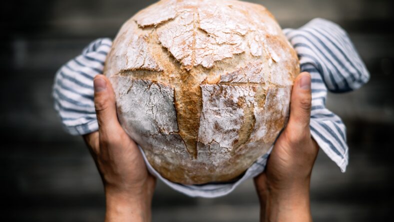 Traditional leavened sourdough bread in baker hands