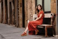 young woman sitting on street bench