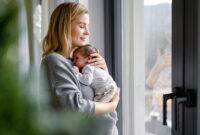 Loving mother hugs her little baby at
