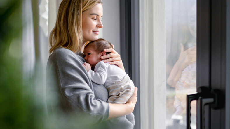 Loving mother hugs her little baby at