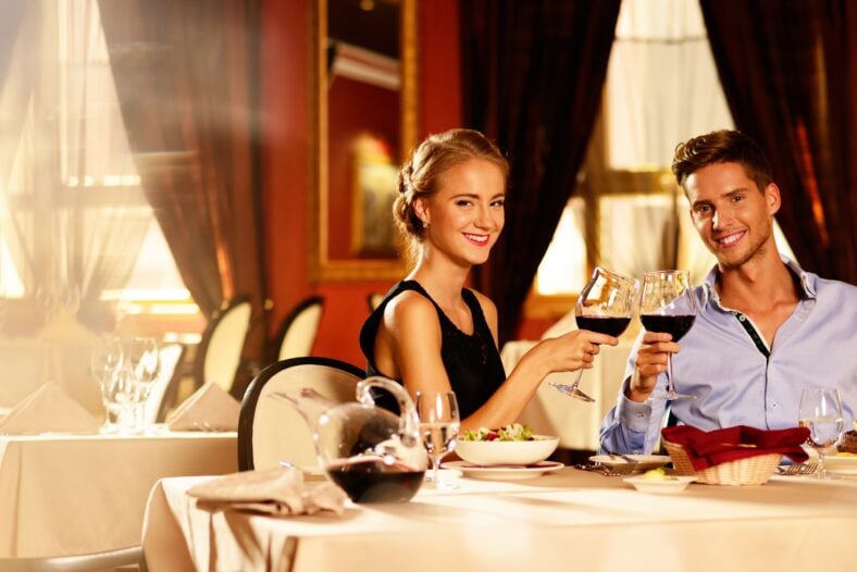 Beautiful young couple with glasses of red