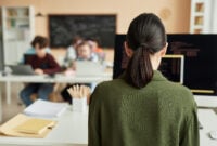 Back view at female teacher using computer