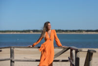Pretty young blonde woman in orange dress