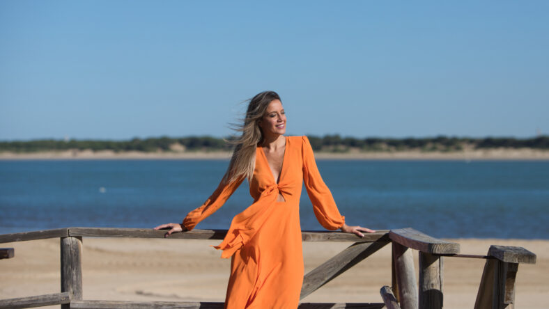 Pretty young blonde woman in orange dress