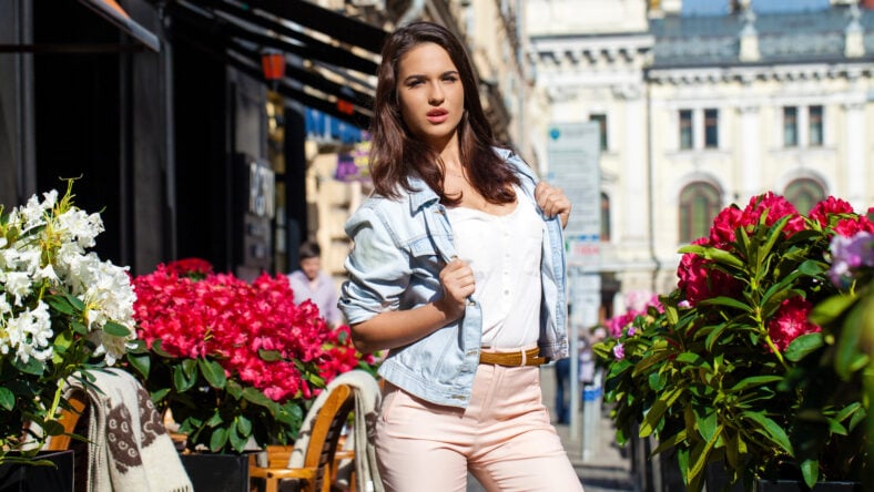 Young brunette woman in jeans jackets walking