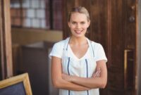 Smiling blonde waitress with arms crossed