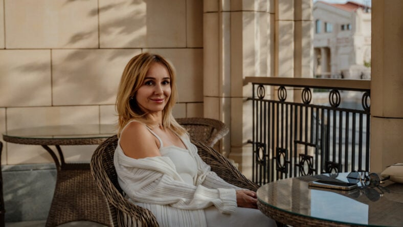 A woman in a white robe sits