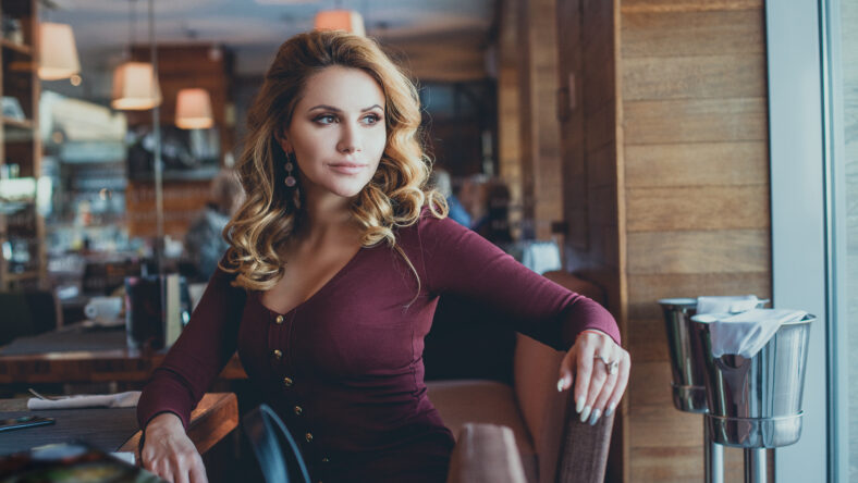 Beautiful Young Woman Waiting in a Cafe