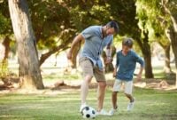 Father, boy and play with football at