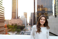 Beautiful young woman sitting on a bridge