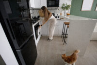 Brunette woman opening oven in modern kitchen