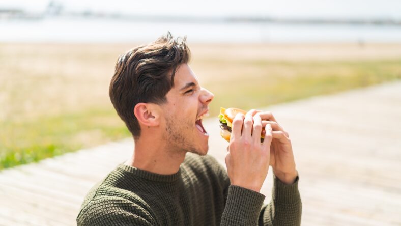 Young caucasian man at outdoors holding a