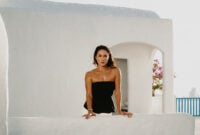Woman leaning on white balustrade on sunlit